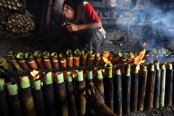 warga yang sedang jongkok untuk meratakan bara